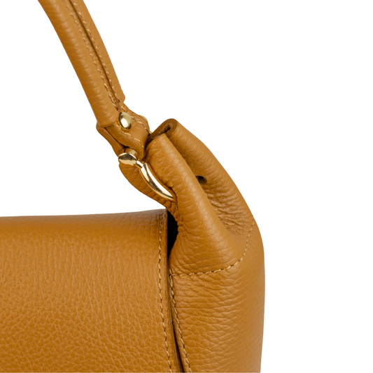 Détail de l’anse et des finitions dorées du sac Naomi en cuir cognac