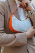 Détail du sac Clara mini tenu à la main, look chic urbain